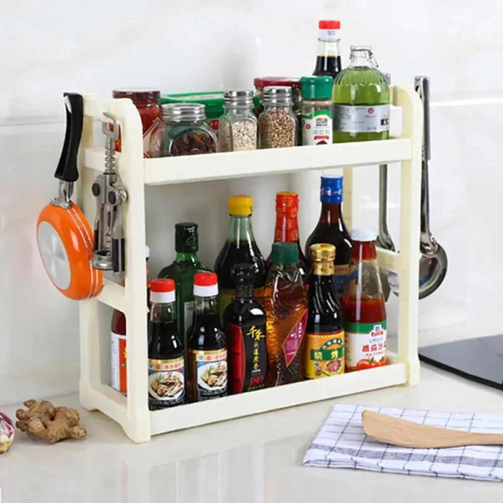 Cream-colored plastic multilayer two tier kitchen spice and utensil organizer rack with integrated hooks holding utensils and corkscrew