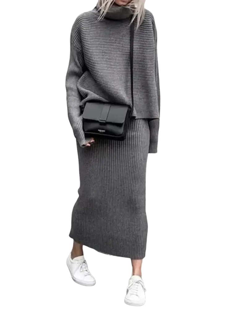 Black rectangular crossbody bag with minimalist flap closure and subtle branding paired with knit sweater set long sleeve midi skirt