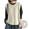 Beige knitted sleeveless vest worn over black long-sleeved top in solid color pullover layered dress style