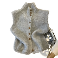 A soft fluffy gray knit sleeveless vest with high neck and brown wooden buttons suitable for layering