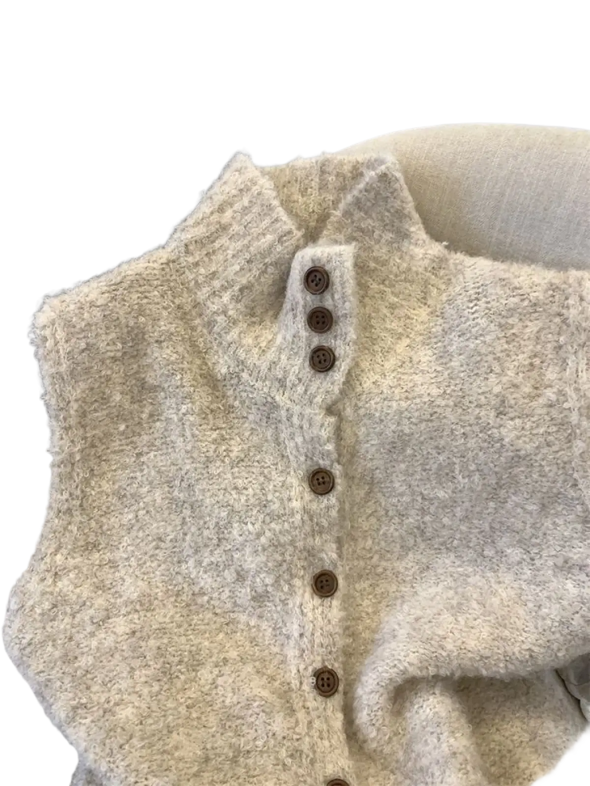 Cozy off-white fuzzy knit vest with high neck and dark brown wooden buttons down the front