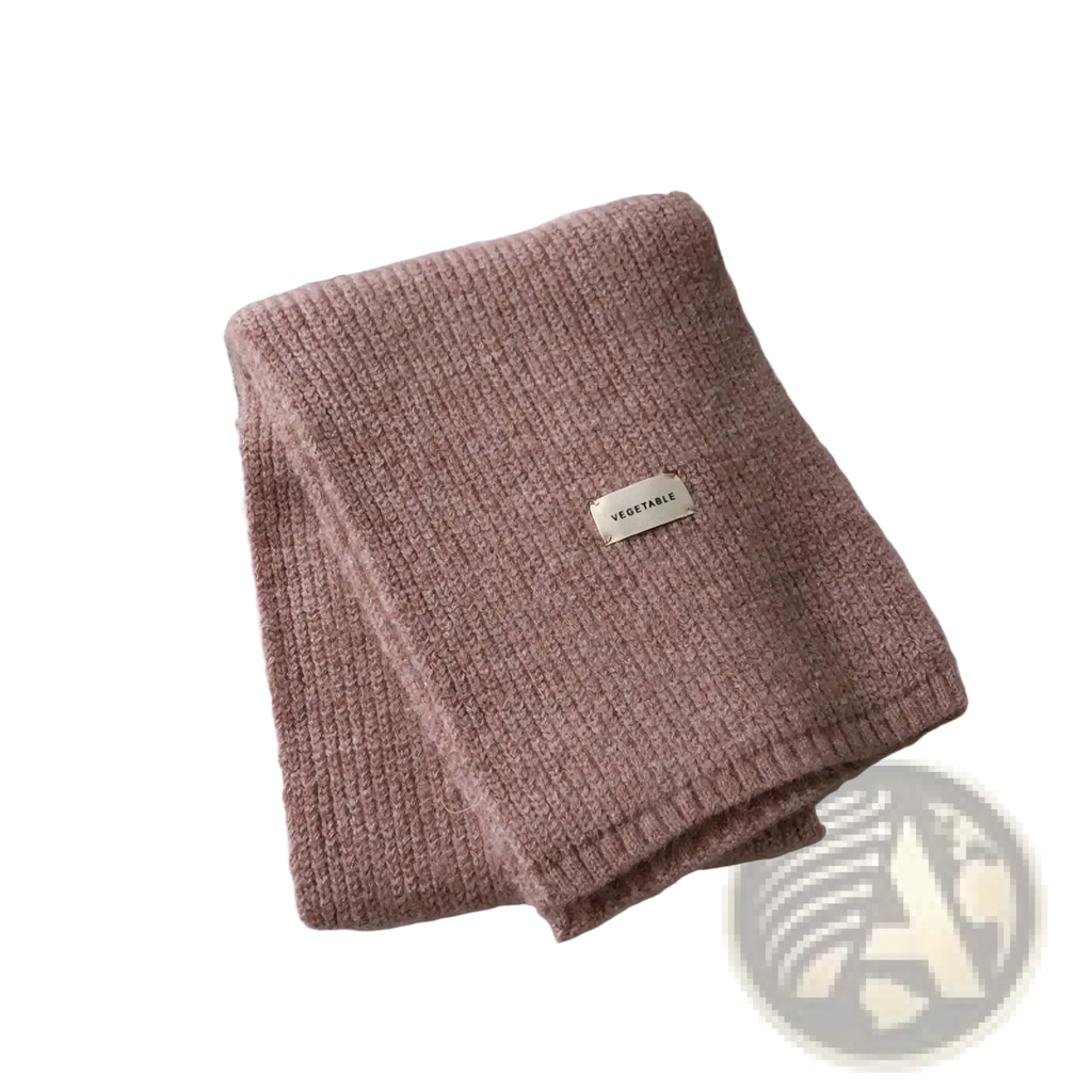 A soft pink ribbed knit cashmere winter scarf for women with a small rectangular vegetable label stitched on