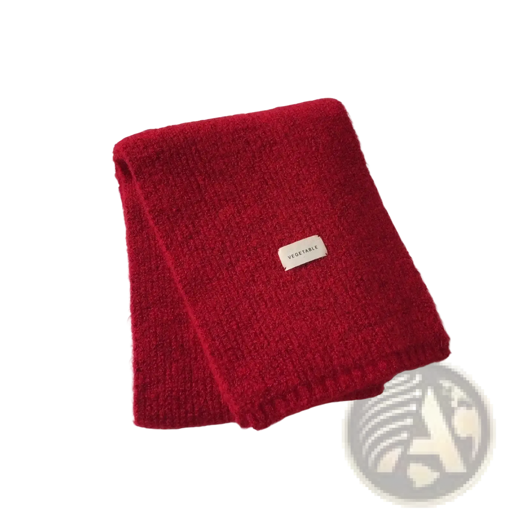 A vibrant red knitted cashmere winter scarf for women with a soft textured surface and a small white vegetable label