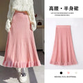 A soft pink knitted midi skirt with high waist pleats and a fluffy ruffled hem made of ribbed knit fabric