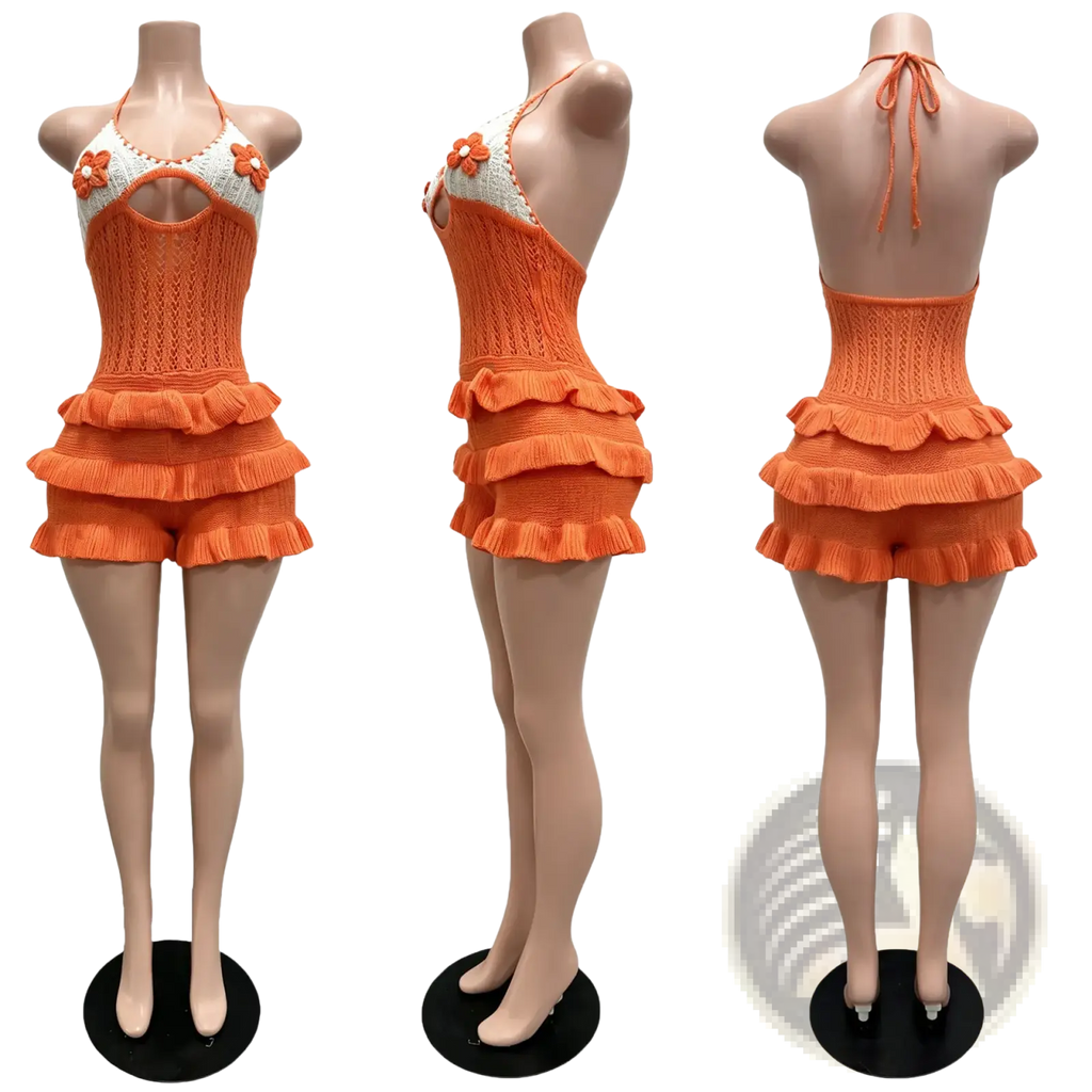 Orange knitted halter romper with ruffled shorts and floral embellishments for summer playsuit wear