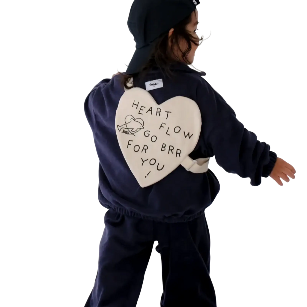 Back side of navy blue fleece jacket with cream heart patch featuring black embroidered text and illustration for Korean kids heart crossbody bag product