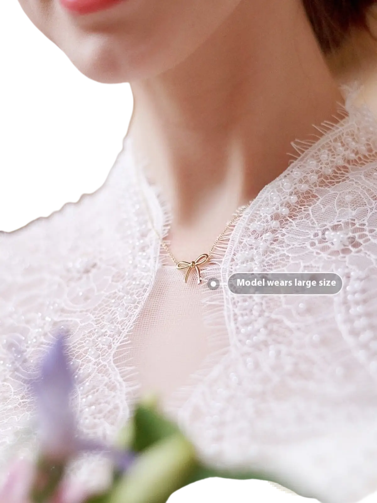 Korean style gold bow pendant clavicle necklace with fine chain worn over white lace fabric
