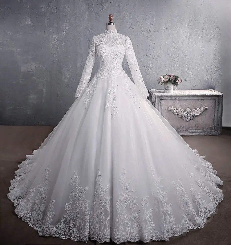 A white embroidered lace stand collar wedding gown with long sleeves and a flowing train
