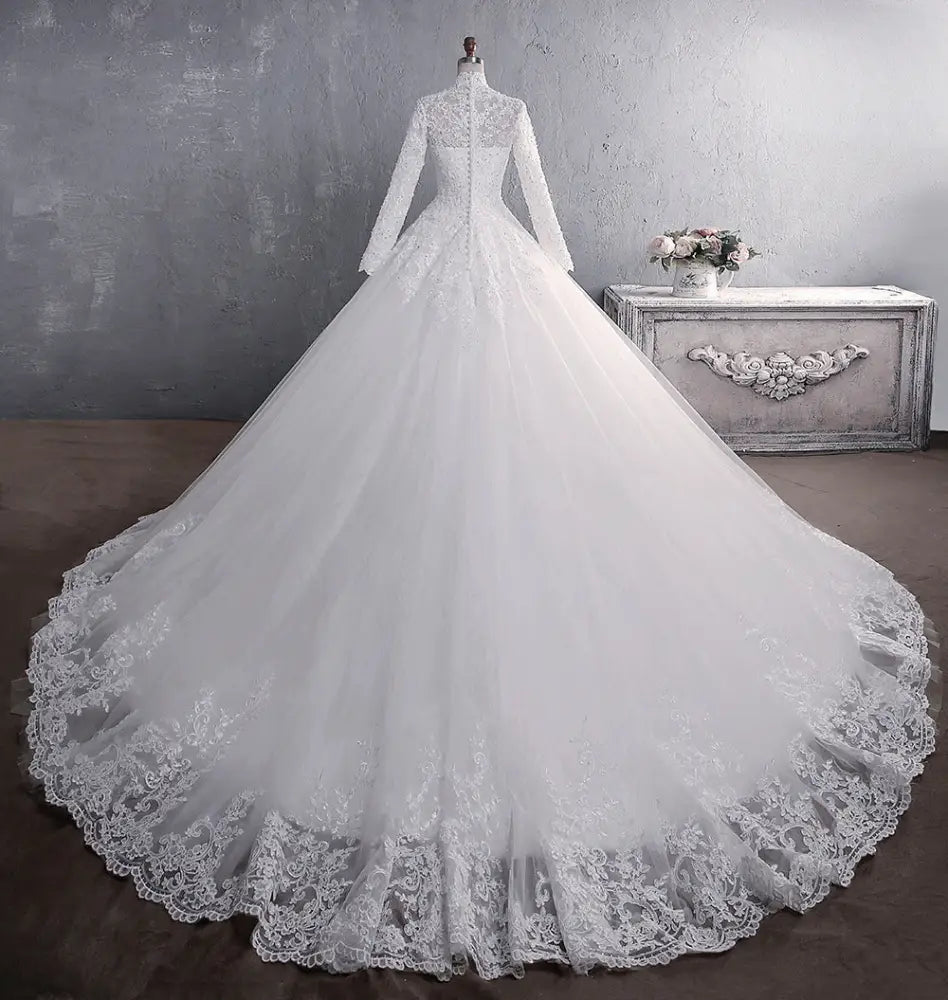 White lace embroidered stand collar wedding gown with long sleeves voluminous skirt and floral detailing