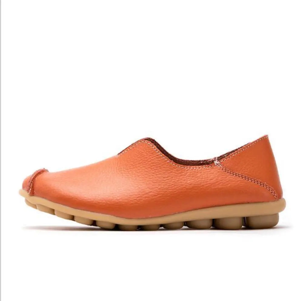 Premium genuine leather slip on flat shoe in orange with textured surface and chunky light brown rubber sole