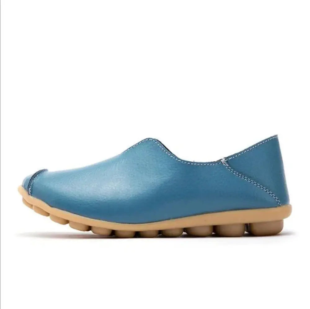 Premium genuine leather blue slip on flat shoe with tan rubber sole and segmented bubble tread pattern