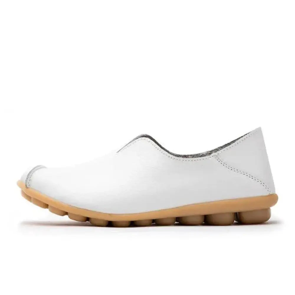 Premium genuine leather slip on flat shoe in white with tan rubber sole and subtle stitching details