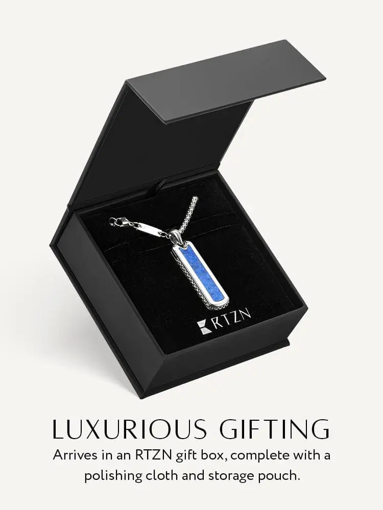 A sleek silver stainless steel dog tag necklace with vibrant blue lapis lazuli inlay in a black rtzn gift box