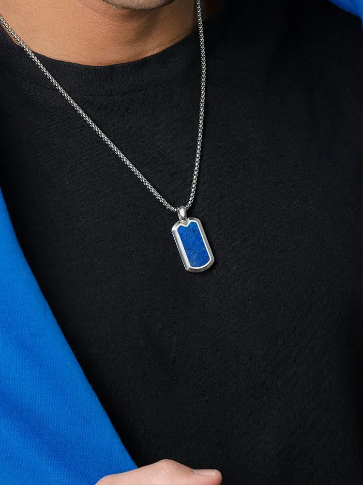 Silver dog tag necklace with vibrant lapis lazuli blue inlay suspended on a matching silver chain