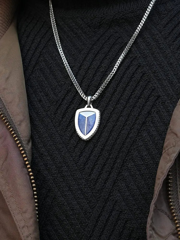 Silver shield pendant in 316l stainless steel with blue lapis lazuli inlay and textured edge on matching chain