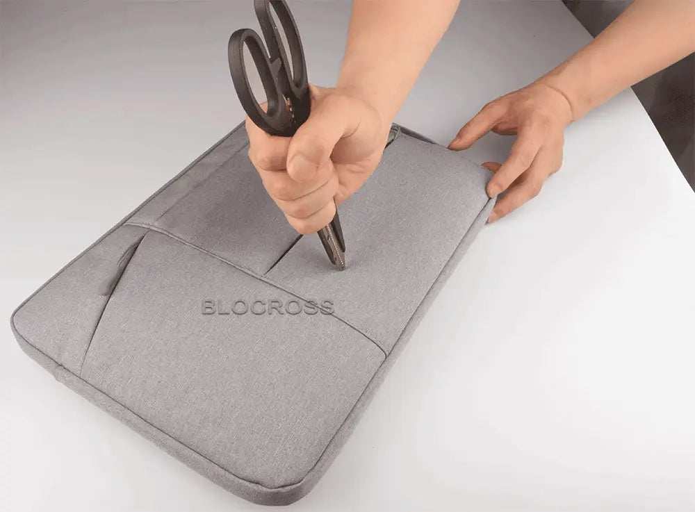 Gray textured laptop sleeve bag with subtle bloccross branding designed for macbook air and pro models