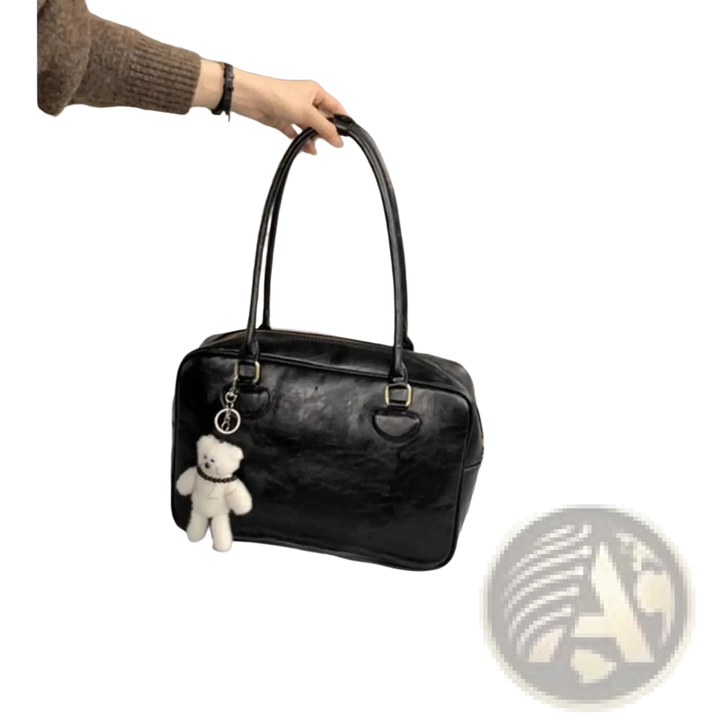 Black patent leather large capacity shoulder bag with white teddy bear charm hanging from the handle