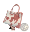 A large capacity plush tote bag with soft fluffy pink and white cow print and matching handles