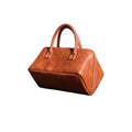 A large tan pu leather travel makeup and toiletry organizer with rounded top handles and a structured shape