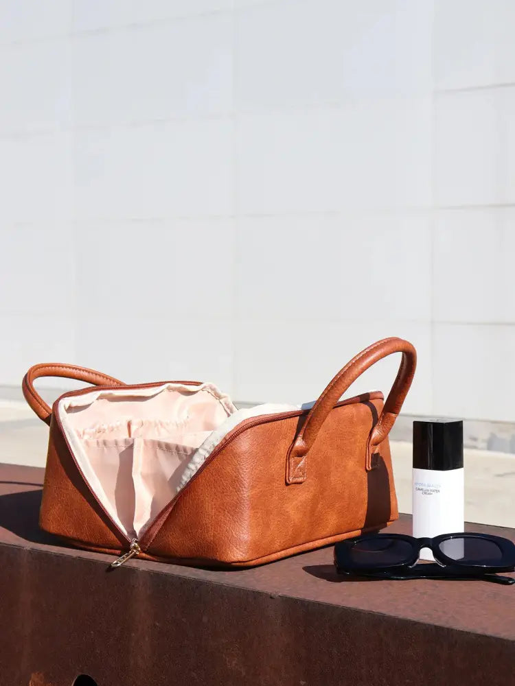 Large tan pu leather travel makeup and toiletry organizer with brown leather exterior zippered opening and pink lining