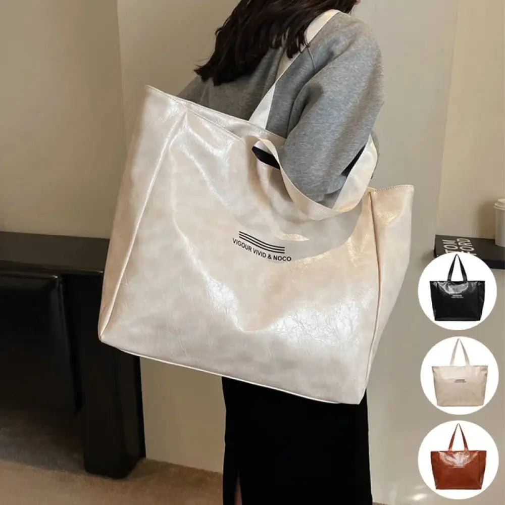 A large waterproof glossy shoulder tote bag in off-white with a minimalist black logo and matching handles shown in multiple colors