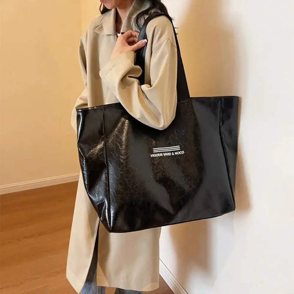 Large waterproof glossy black tote bag with white vigour vivid and noco text on the front designed for shoulder use