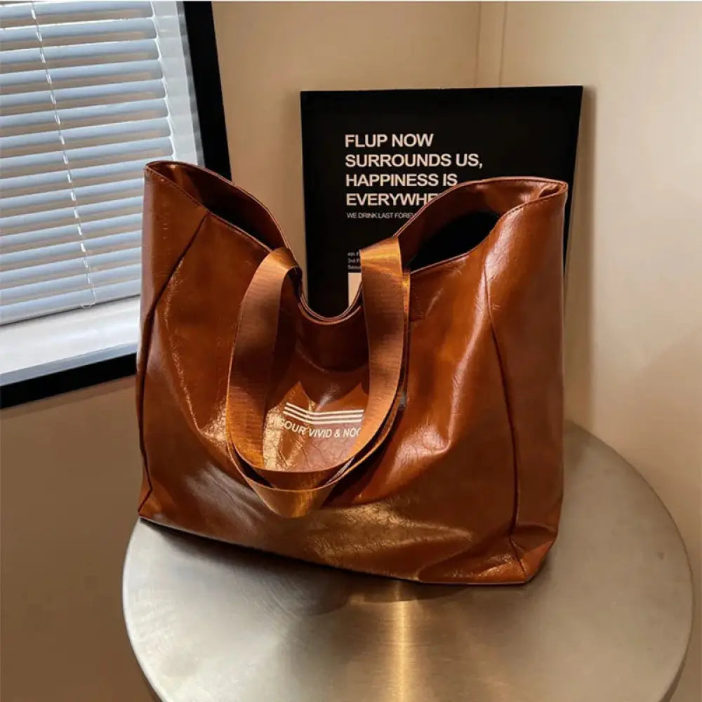 Large waterproof glossy brown leather shoulder tote bag with gold foil branding on the front