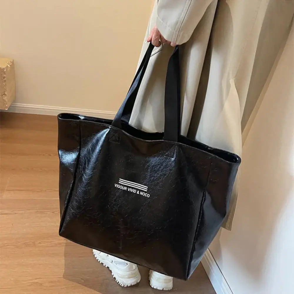 Large waterproof glossy black tote bag with white vigour vivid noco text and three horizontal lines on front