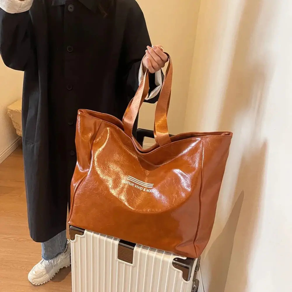 Large waterproof glossy brown tote bag with matching handles and subtle white logo across the front