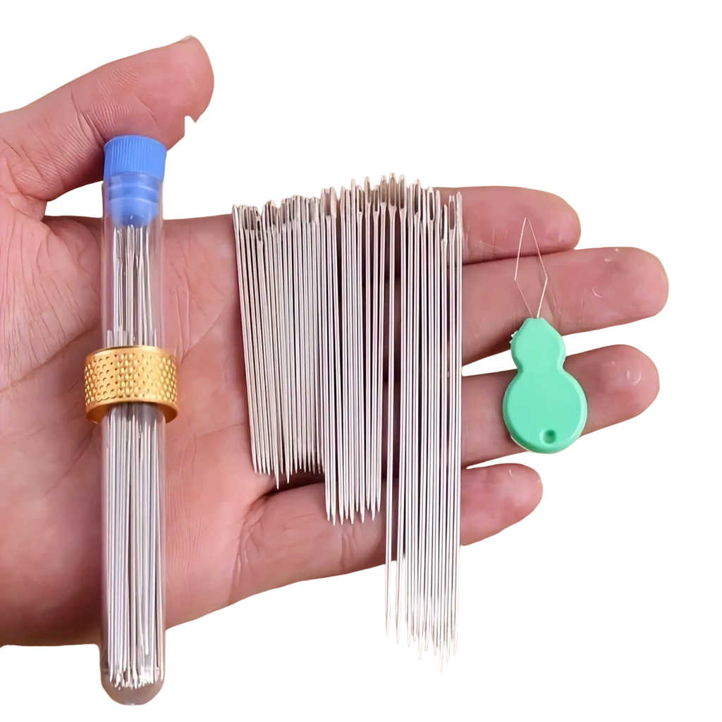 A set of silver metal large eye sewing needles with a green plastic threader in a clear tube with blue cap and gold band