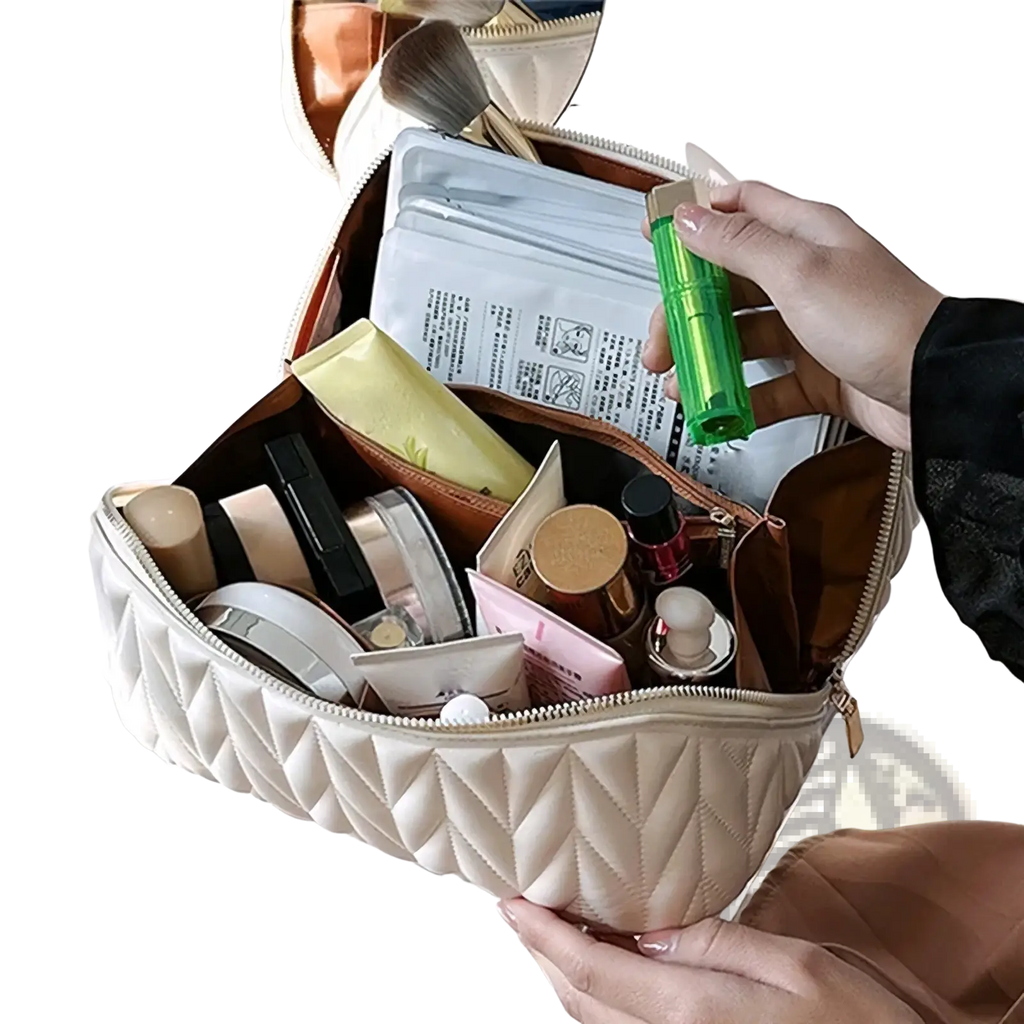 Cream-colored quilted leather large travel makeup bag with zipper closure filled with assorted beauty products