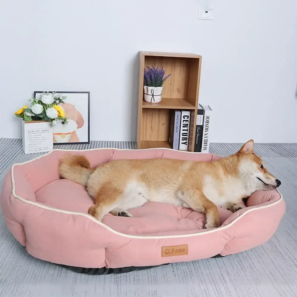 Large pink plush sofa sleeping bed for dogs with cream trim and brown leather tag for comfortable pet rest