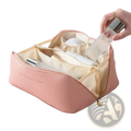 Large travel makeup bag in pink faux leather with cream interior and gold zipper pull for toiletry organization