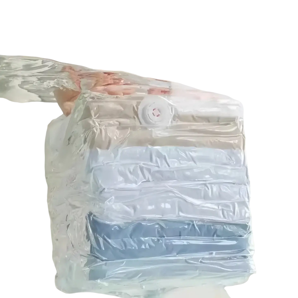 Transparent large vacuum storage bag with white valve containing neatly folded light blue and gray clothes for quilts