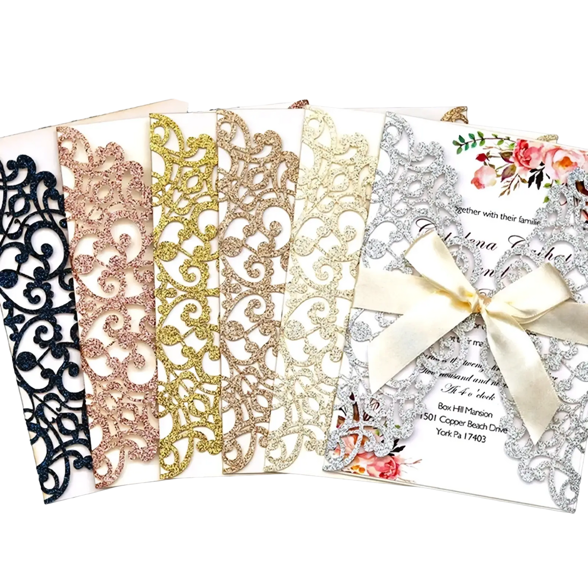 Elegant laser cut wedding invitation cards in shimmering metallic with delicate floral designs and satin bow accents