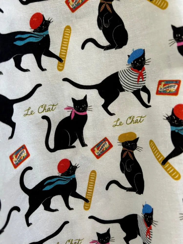 Le chat parisian cat print cotton skater skirt featuring black cats in parisian attire on light fabric with gold baguettes