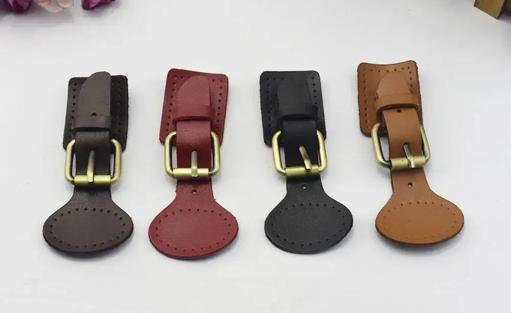 Four handcrafted oval leather hook fasteners with brass hardware in dark brown red black and tan colors