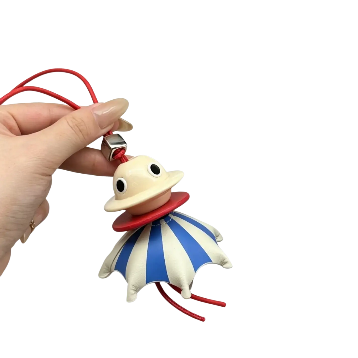 A beige and red leather umbrella-shaped animal bag charm with blue and white striped fabric and a red cord keychain
