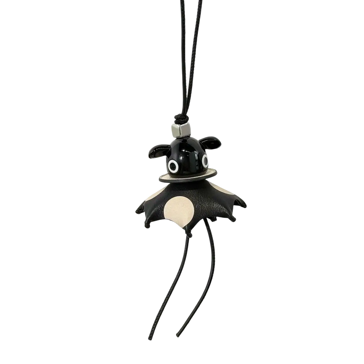 Leather animal bag charm in black and cream bat shape with silver metal clasp hanging from black cord keychain