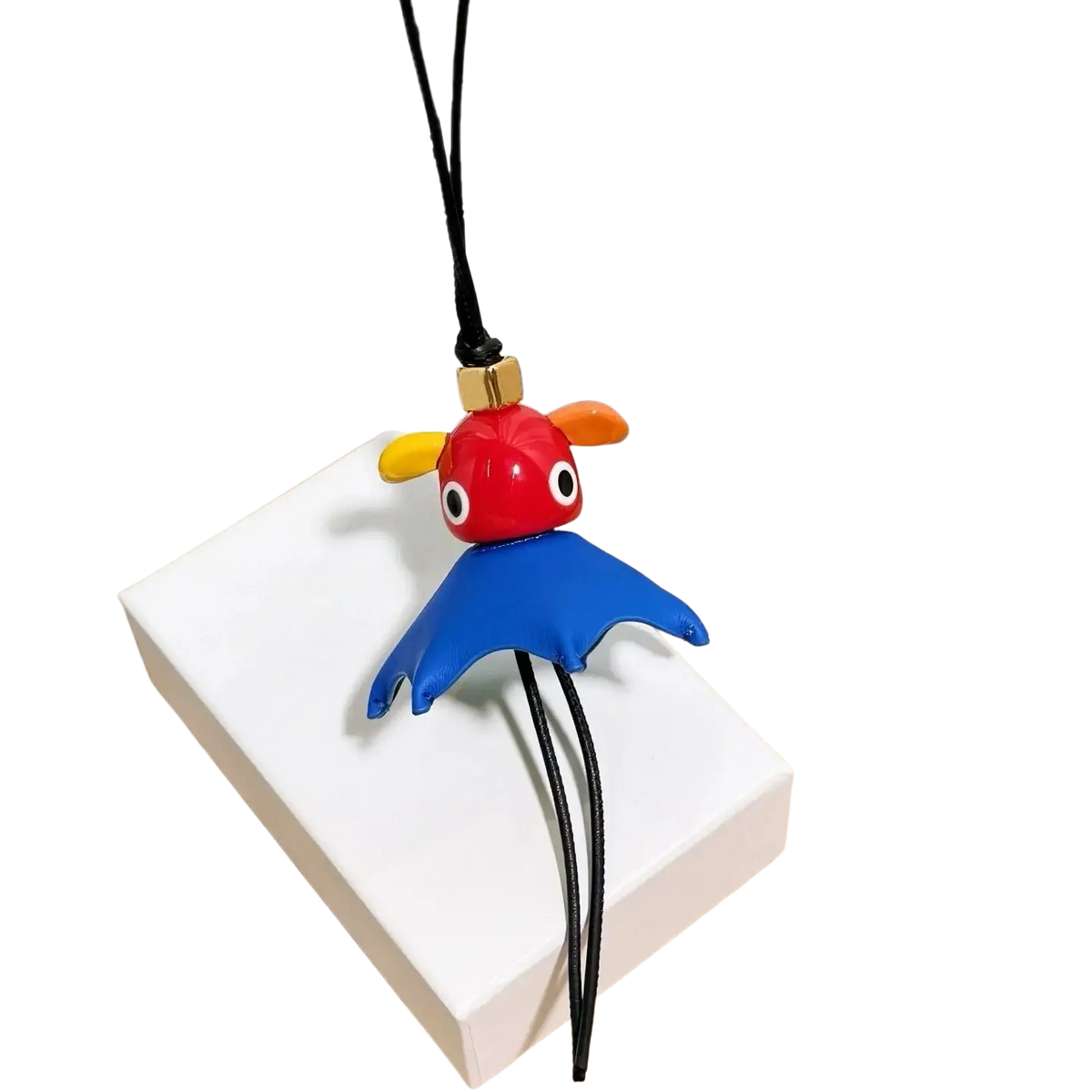 Leather animal bag charm keychain with vibrant red and blue plush, yellow ears, black string, and gold clasp