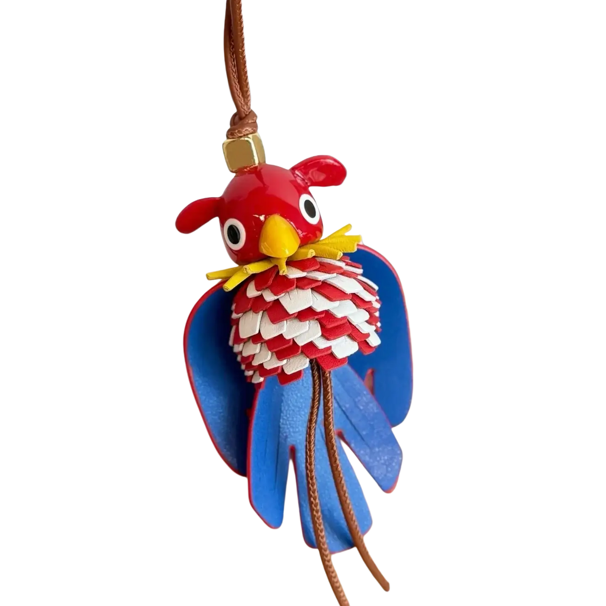 Leather animal bag charm keychain shaped like a vibrant red and blue parrot with layered leather scales and braided cord