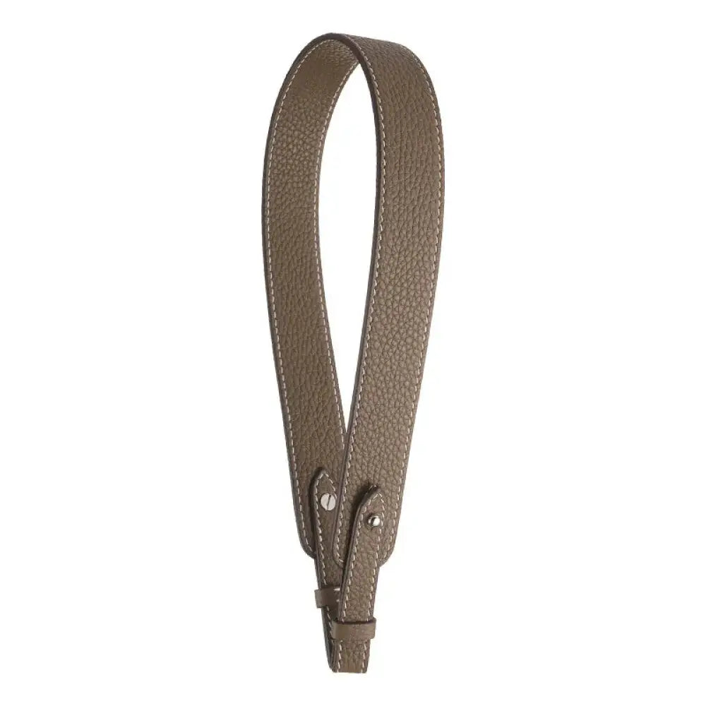 Adjustable textured taupe leather handbag strap with precise stitching and gold metallic clasp hardware