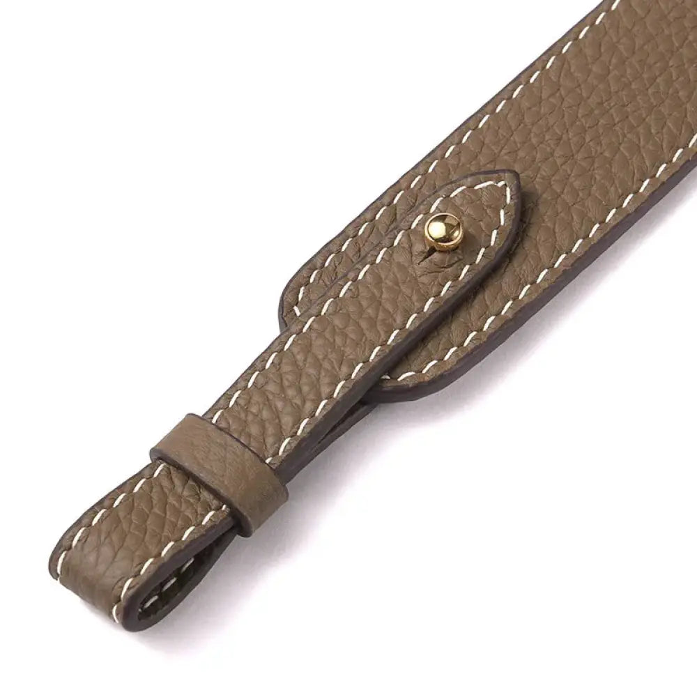Adjustable textured leather handbag strap in brown with white stitching and a gold-tone metal clasp