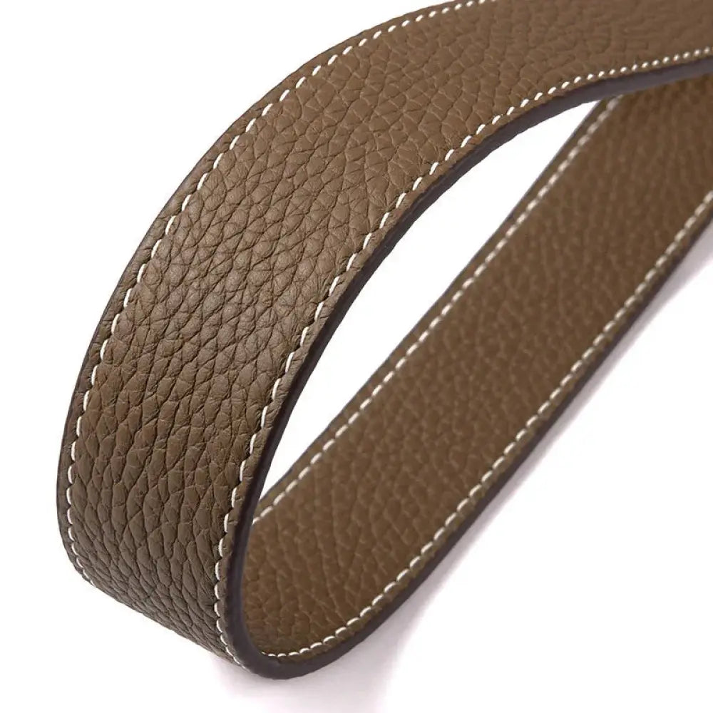 Adjustable textured leather handbag strap in brown with white stitching and dark brown inner lining with gold clasp