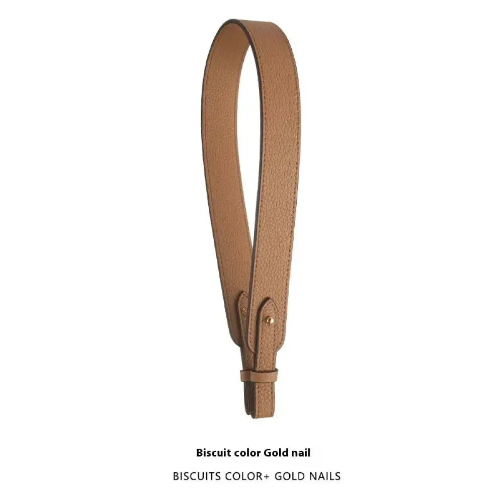 Adjustable textured leather handbag strap in biscuit color with gold nail hardware and gold clasp detail