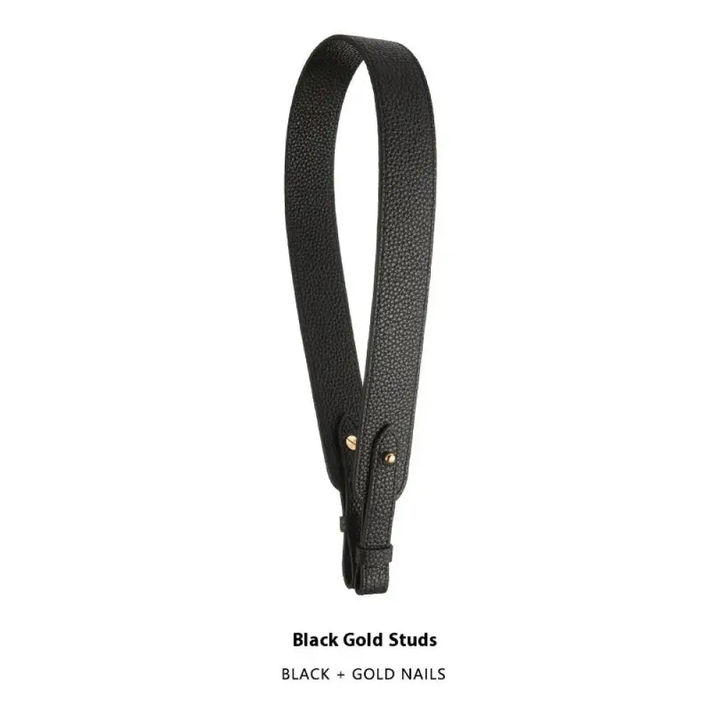 Adjustable black leather handbag strap with textured surface and gold-tone metal studs at attachment points