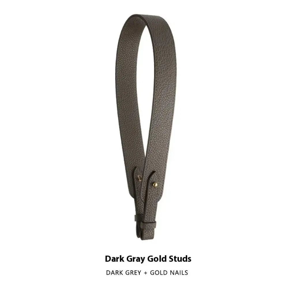 Adjustable dark gray textured leather handbag strap with gold nail accents and gold clasp