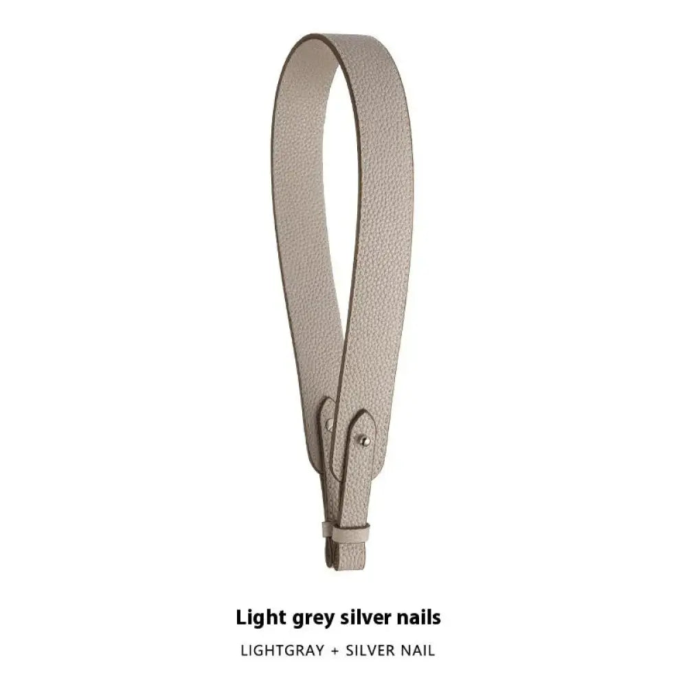 Adjustable textured leather handbag strap in light grey with silver nail hardware and gold clasp for versatile use