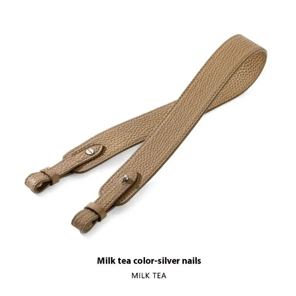 Adjustable textured leather handbag strap in milk tea color with silver-toned metal hardware and gold clasp
