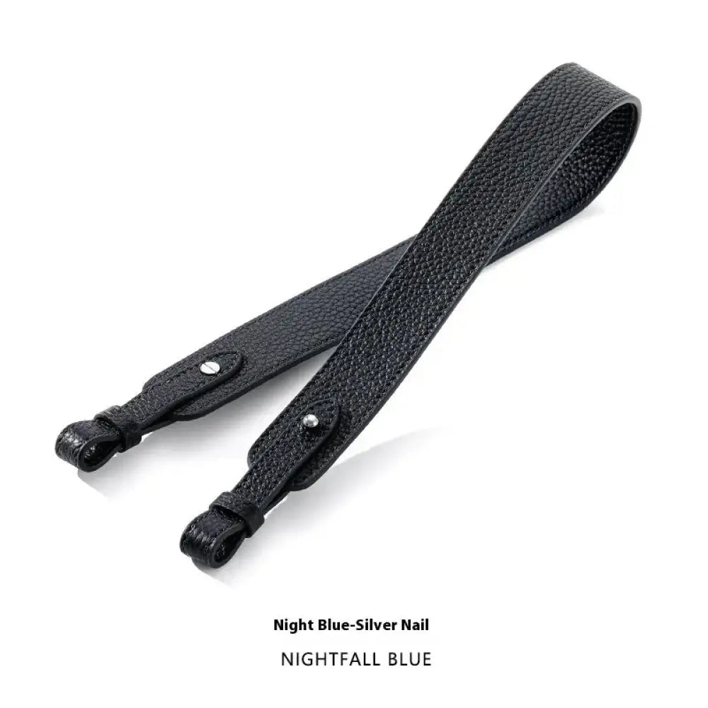 Adjustable black textured leather camera strap with silver nail accents and gold clasp for handbag use